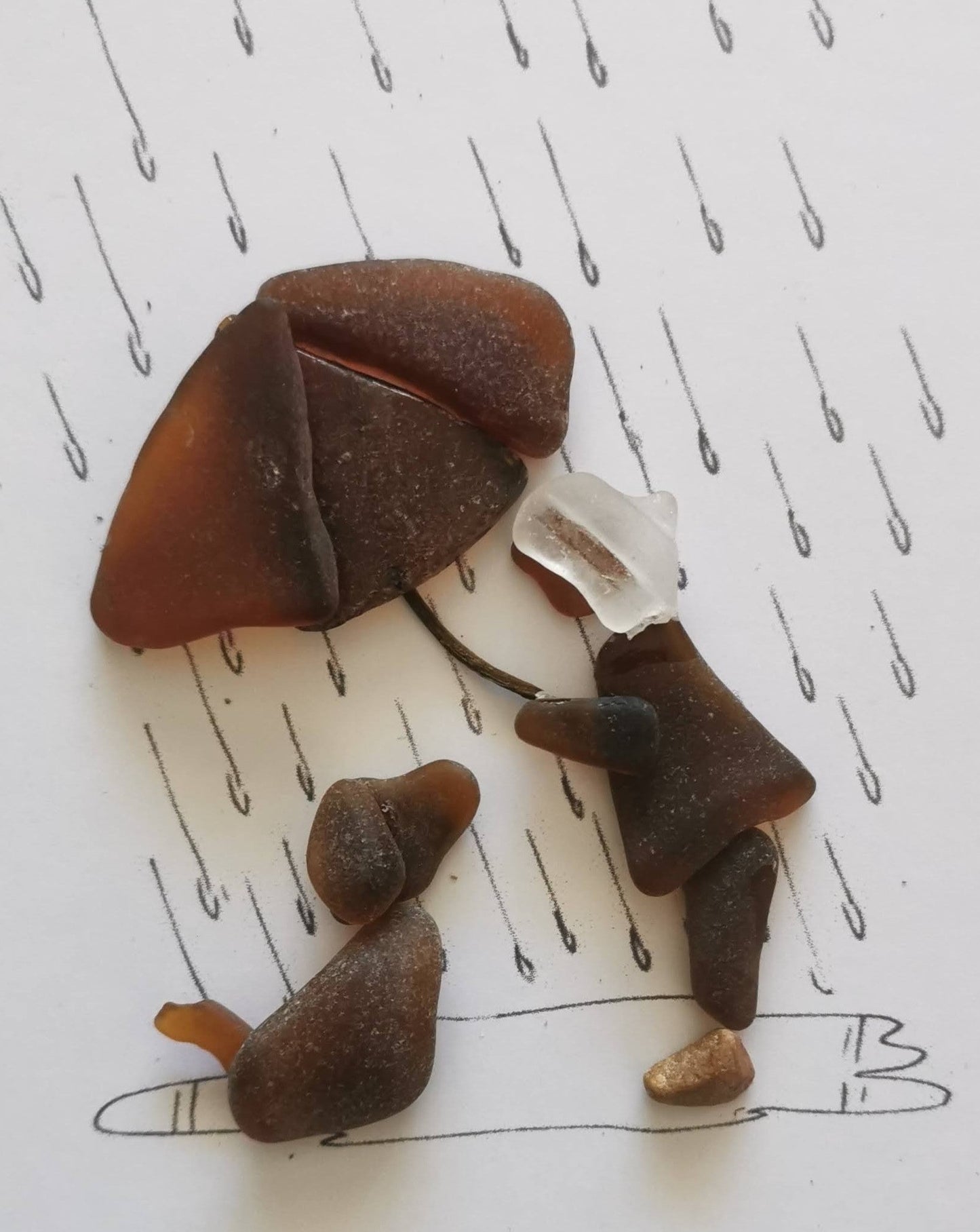 sea glass. girl holding un umbrella over dog in the rain.